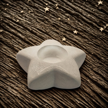 star tealight holder on a wooden surface with star decorations.