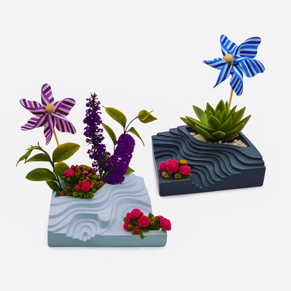 Three decorative planters with flowers and pinwheels on a white background