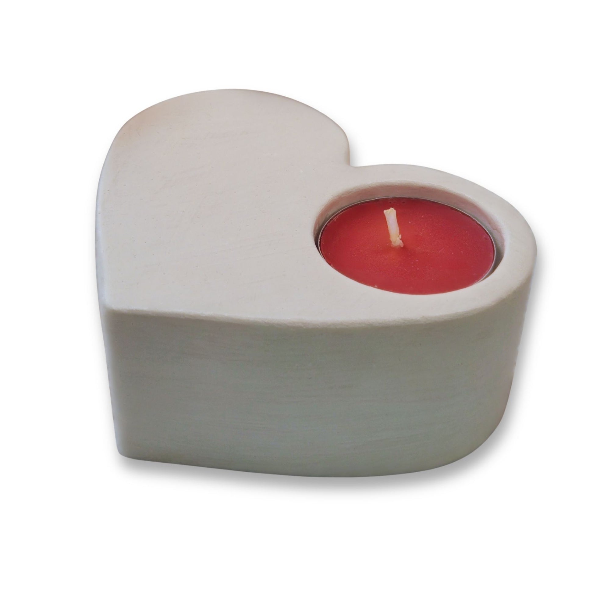 Heart-shaped candle holder with a red candle on a white background